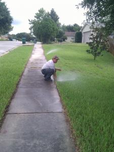 Adjusting popup head during sprinkler repair in Hialeah Gardens